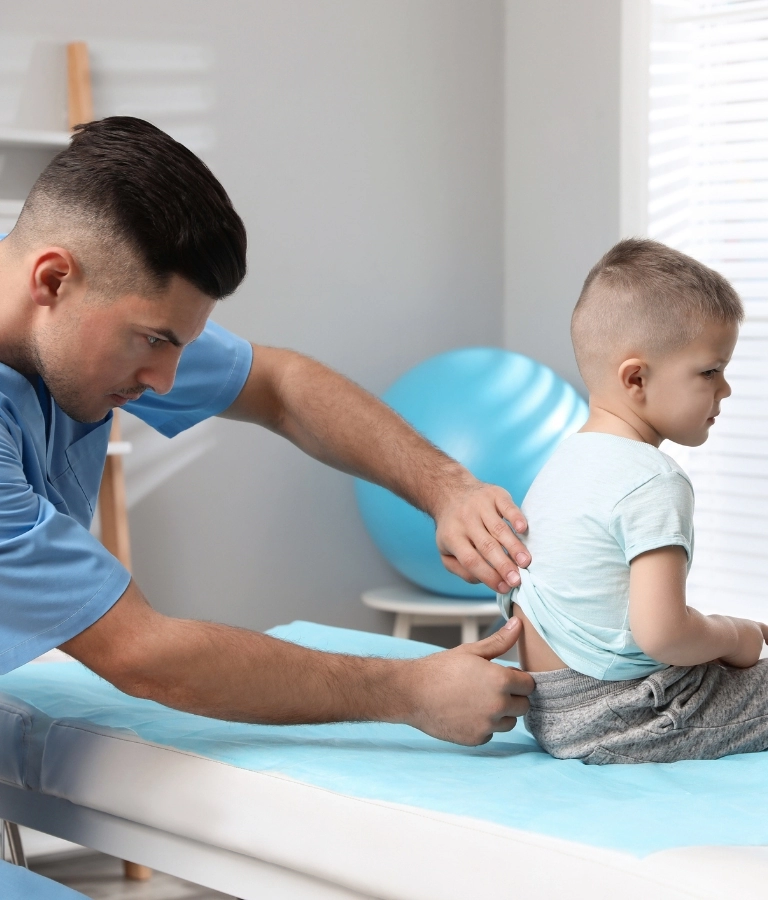 Leczenie wad postawy badanie kciukiem lekarza kręgosłupa dziecka